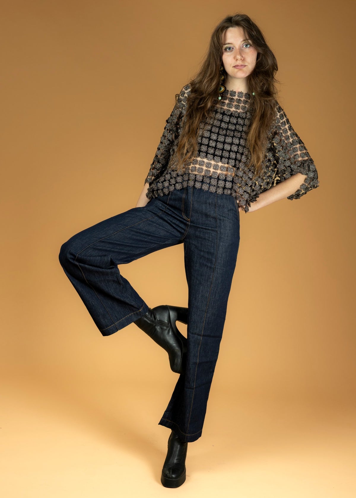 Top ajouré marron à fleurs pailletées porté avec un jean brut large et des boots