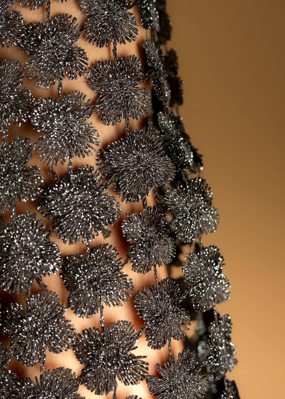 Détail des fleurs brodées au fil pailleté marron et argent du top ajouré